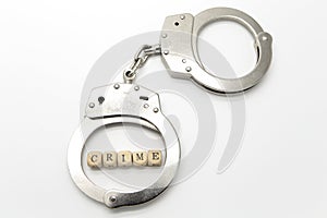 Handcuffs with word crime on wooden cubes