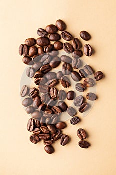 A handful of arabica coffee beans. Vertical photo for coffee houses, screensavers, roasters and coffee makers.