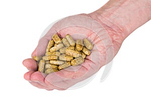 Handful of brown spotted vitamins in male hand