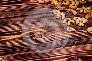 A handful of cashews are scattered on a wooden table. place for the inscription