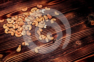 A handful of cashews are scattered on a wooden table. place for the inscription