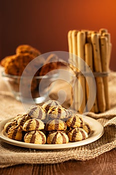 A handful of cookies on a plate, breadsticks and oatmeal cookies