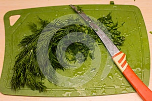 Handful of finely chopped green onions on striped wooden board