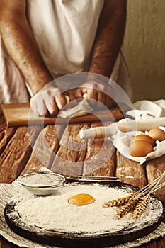 A handful of flour with egg on a rustic kitchen