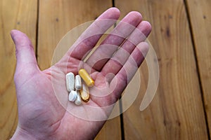 A handful of health supplements over wooden counter photo