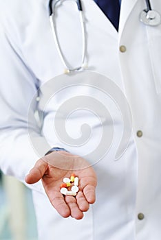 Handful of little lifesavers. Closeup of a doctors hand holding different types of medication.