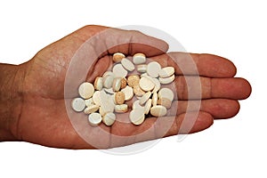 Handful of pills in palm of hand on white background, close-up.