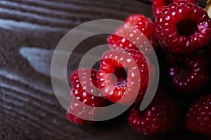 A handful of raspberries close up on a brown background