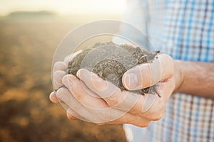 Handful of soil, close up of farmer`s hands