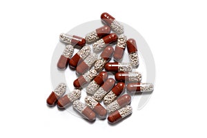 A handful of two-tone tablets on a white background, capsules with granules inside, vitamins, care health