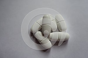 Handful of white caplets of calcium citrate