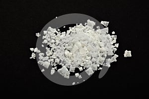 Handful of white Cyprian pyramid sea salt on black