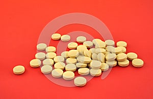 Handful of yellow tablets on red