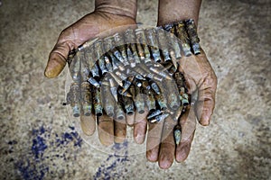 Handfull of old unused bullets, two hands giving old bullets