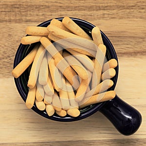 Handfull of short thin white crispy bread breadsticks