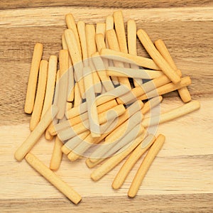 Handfull of short thin white crispy bread breadsticks