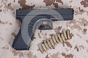 handgun on camouflage uniform