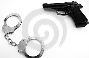 Handgun and handcuffs weapon agression criminal white empty surface, background, concept. photo