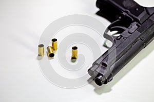 Handgun with 9mm shell casings on white table