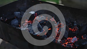 Handheld shot of charcoal in brazier, preparation for bbq photo