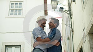 Handheld shot of happy gay couple kissing and hugging