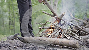 Handheld shot of preparing and lighting up a small fire in the tourist camp in the forest
