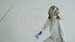 Handheld of Two fencers have fencing training on white background indoors
