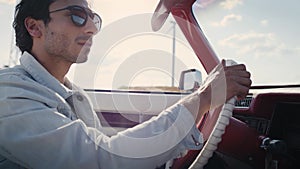 Handheld video of  handsome man driving an antique car.