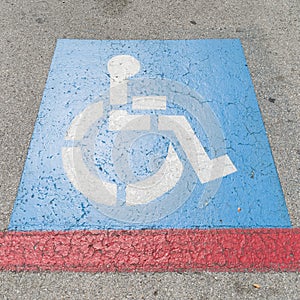 Handicap symbols on asphalt road, parking place reserved for disabled person or people