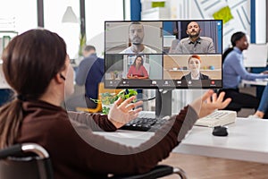 Paralysed project manager talking with team during video conference photo