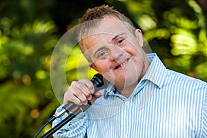 Handicapped boy holding microphone.
