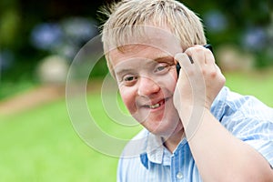 Handicapped boy talking on cell phone.