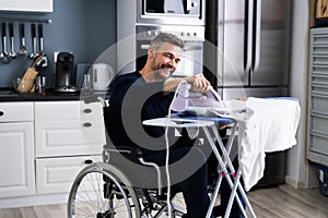 Handicapped Disabled Man In Wheelchair Ironing
