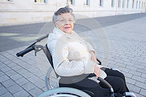 Handicapped elderly woman sitting in wheelchair outdoor