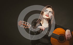 Handicapped girl holding guitar.