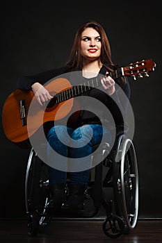 Handicapped girl holding guitar.