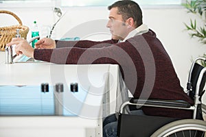 handicapped man sitting on wheelchair in kitchen