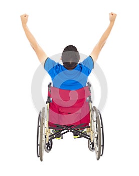 Handicapped man sitting on a wheelchair and raise arms