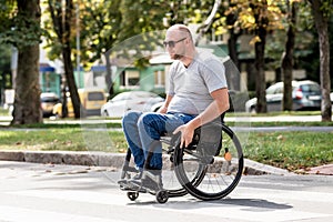 Handicapped man in wheelchair crossing street road