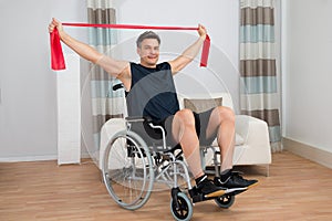 Handicapped man on wheelchair exercising with resistance band