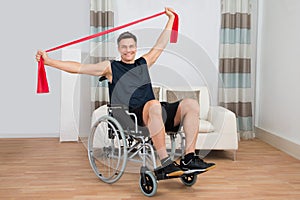 Handicapped man on wheelchair exercising with resistance band