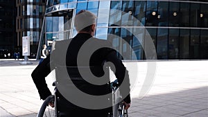 Handicapped man in wheelchair move near modern business centre