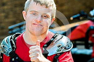 Handicapped motocross rider doing thumbs up.