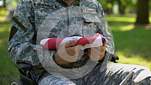 Handicapped peacekeeper holding american flag, country pride, sacrificed hero