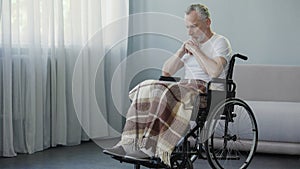 Handicapped person sitting in wheelchair and thinking about life, depression