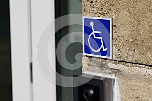 Handicapped sign logo on wall entrance store access pictogram on street shop