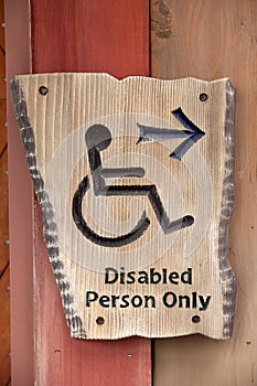 A handicapped sign on wood wall