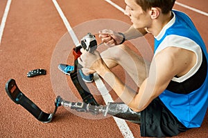 Handicapped Sportsman Repairing Prosthetic Leg photo