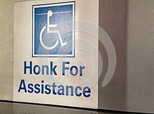 Handicapped symbol on sign stating Honk For Assistance photo