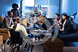 Handicapped young woman with colleagues working in office. She is smiling and passionate about the workflow. Performing in co-